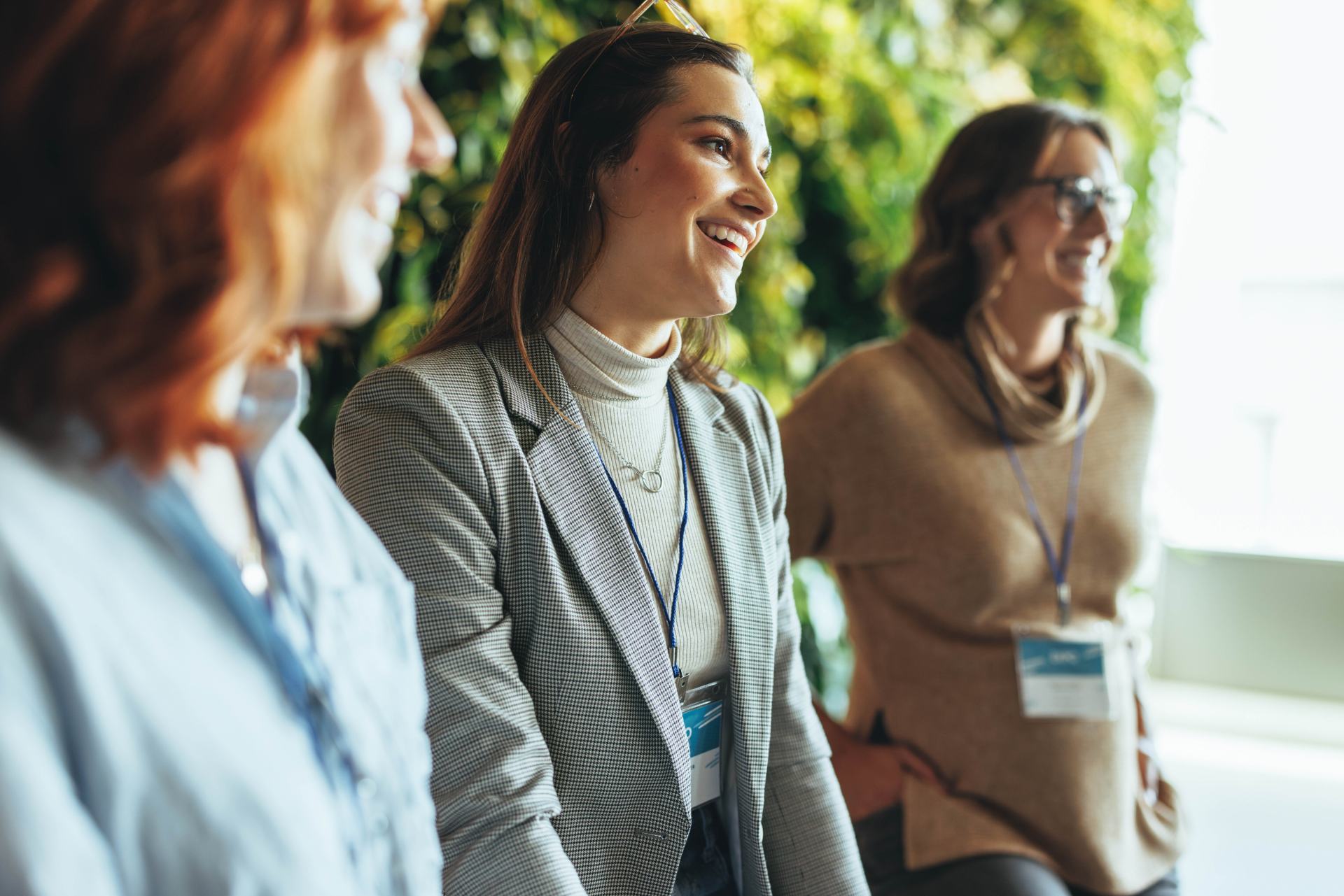 Eine Gruppe von Geschäftsfrauen führt während einer Besprechung eine Diskussion durch, in der Teamarbeit und Zusammenarbeit gezeigt werden. Diese Veranstaltung fördert die Vernetzung und fördert ein positives Arbeitsumfeld für junge Fachkräfte.